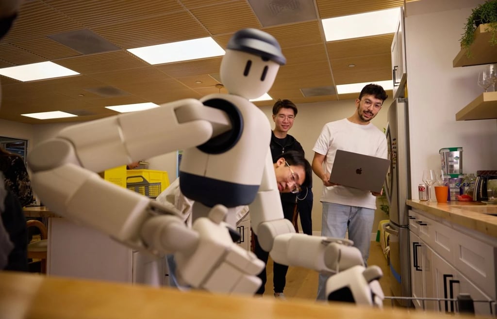 Two engineers watch the Sunday Memo humanoid home robot perform a task in a kitchen setting