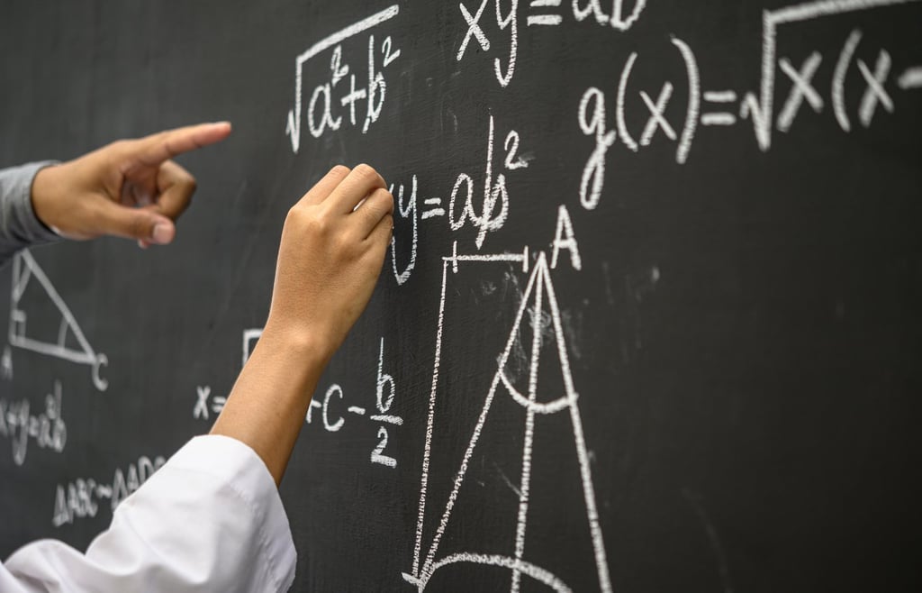 The hand that is written with the white chalk and the hand that shows the formula on the blackboard.