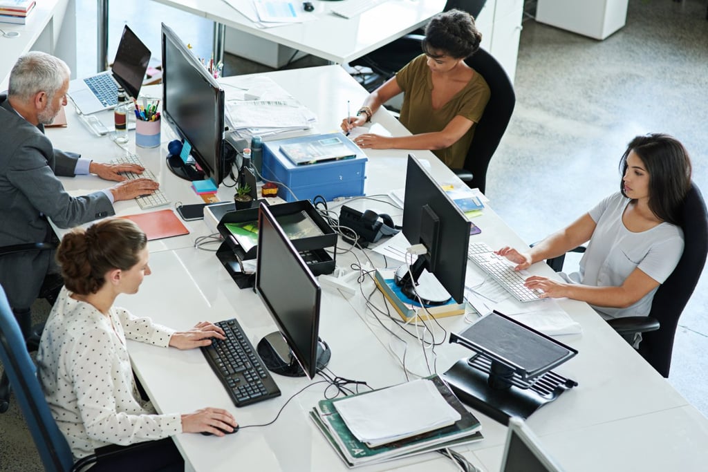 Four employees working hard inside the office.