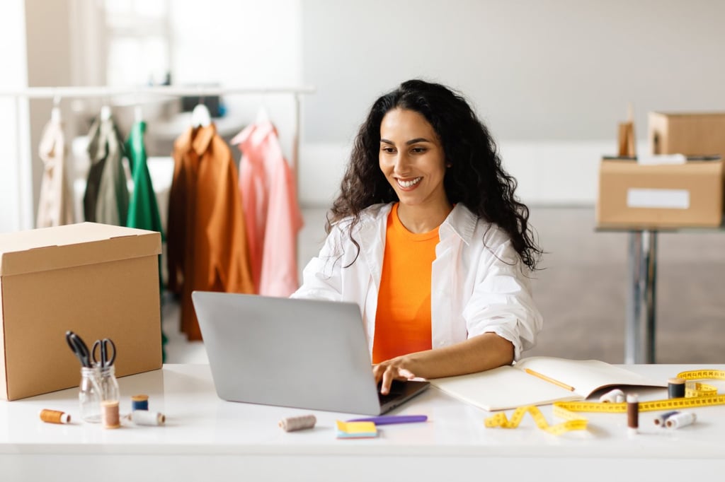 A woman shopping clothes online using her laptop.