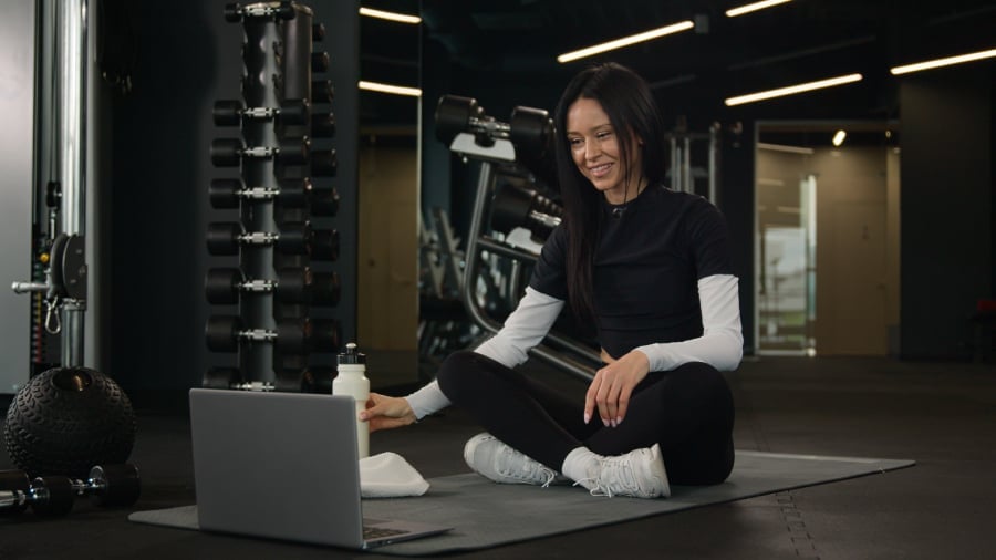 Female gym instructor looking on her laptop.