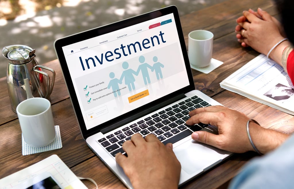 Person using a laptop while browsing on an investment-related website.