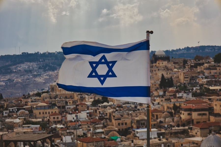 Close-up shot of the flag of Israel with the old city in background.