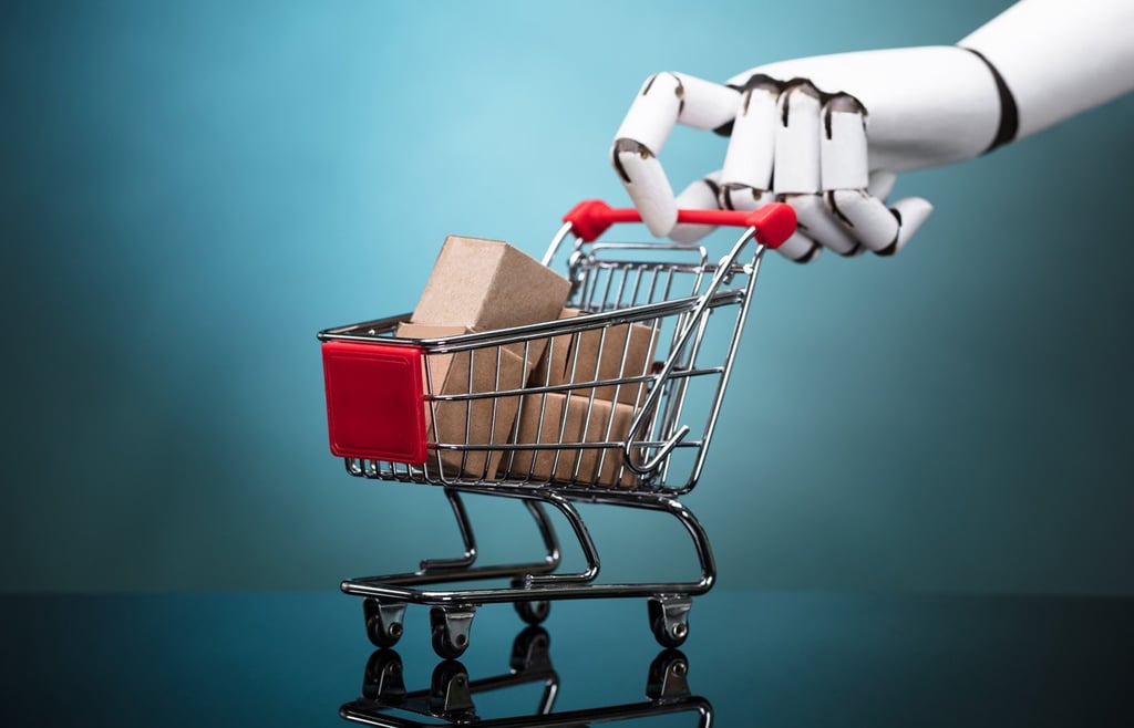 Robot arm holding shopping cart with cardboard boxes.