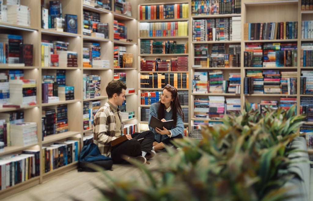 Young man and woman discussing books in a cozy library.
