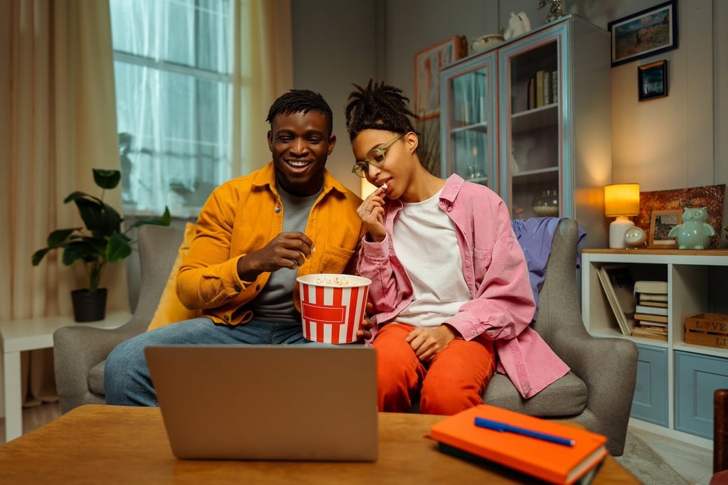 Stock photo of two young adults watching a movie.