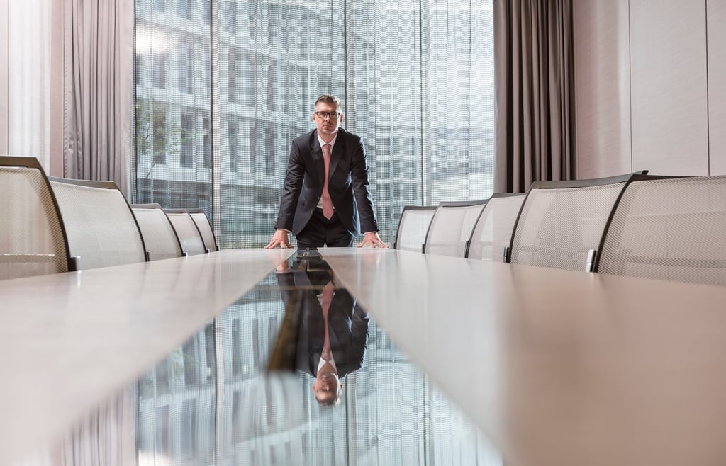 An executive standing on a conference table.