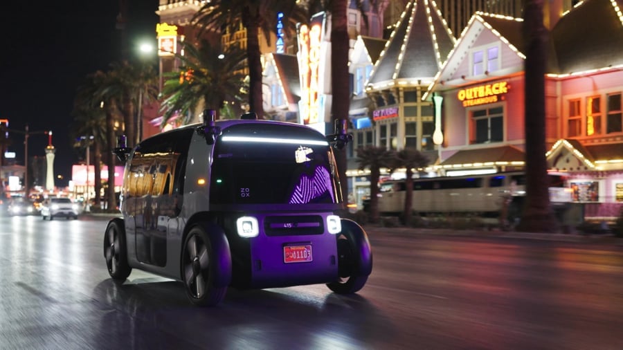 A purple robotaxi running across the city streets.