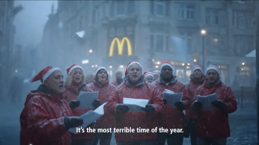 Mcdonalds advertisement of employees singing Christmas carol outside a snowy weather with the Mcdonalds branch.