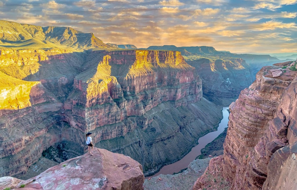 Sunset view of the Grand Canyon with person on edge.