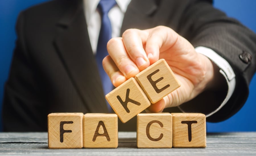 A businessman replacing a fact wooden block with fake.