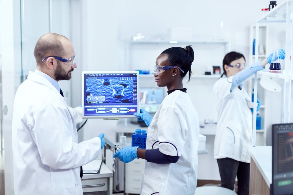 African assitant discussing wtih scientist about virus experiment in chemistry laboratory.