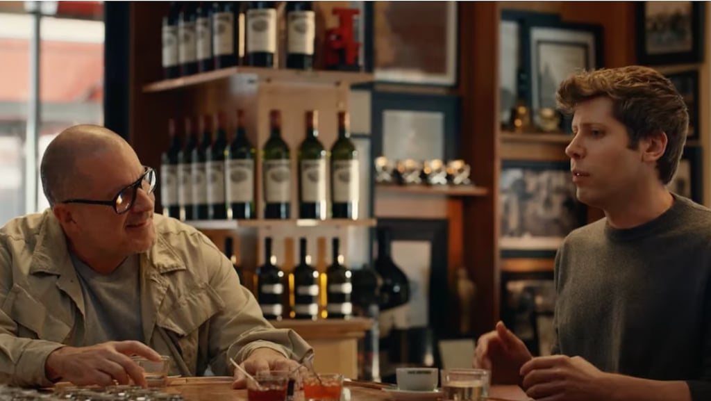 Sam Altman and Jony Ive drinking and talking inside a wine bar.
