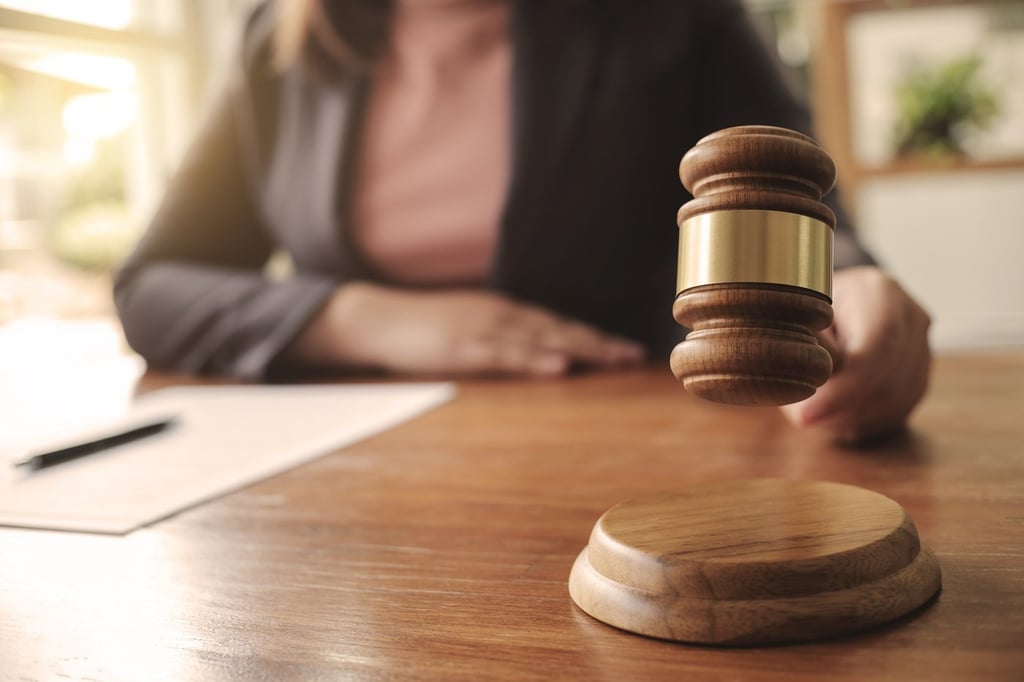 A judge bringing order in the court by smashing the gavel.