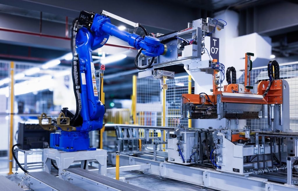 Blue industrial robotic arm on an automated assembly line in a modern manufacturing factory.