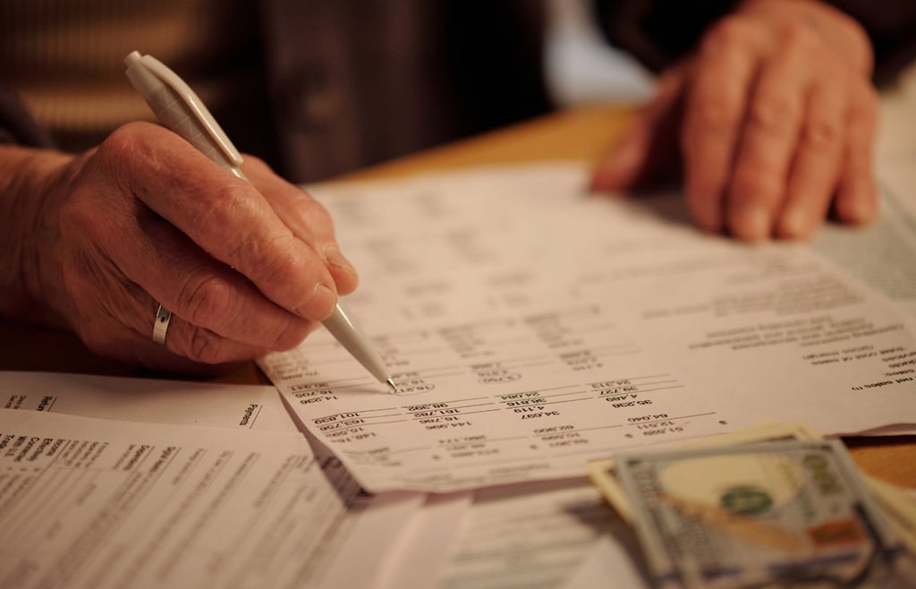 Tax preparation and financial planning concept: person calculating expenses with cash on the table