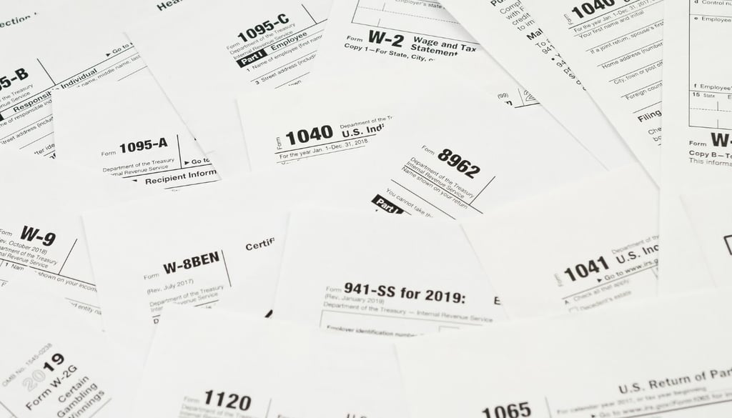Many tax form blanks lies on table