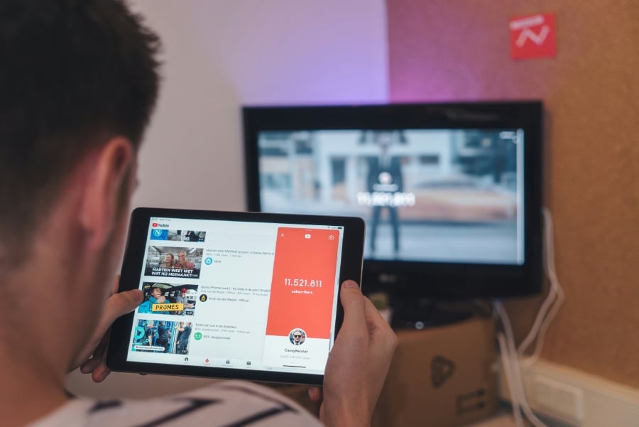 A man watching YouTube videos on his tablet.