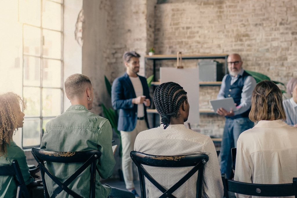 A group of professionals sit attentively during a business meeting in a bright, modern office. The atmosphere is collaborative and focused as ideas are shared and discussed.