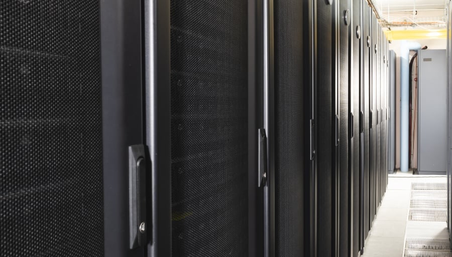 Data center with multiple rows of fully operational server racks.