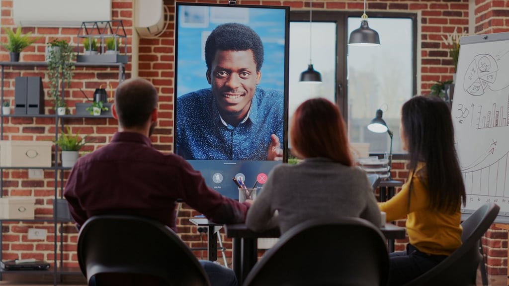 Group of workmates attending video call meeting with man