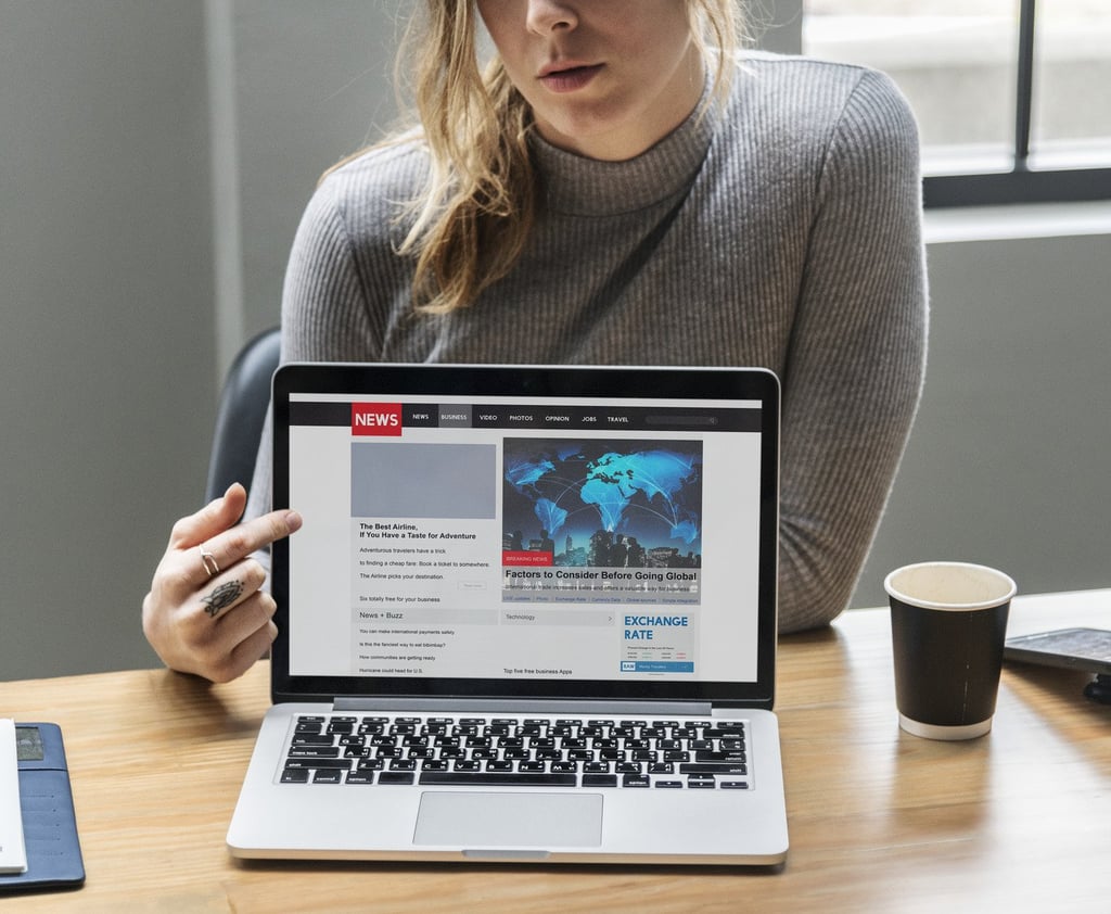 Blond woman pointing at a laptop screen