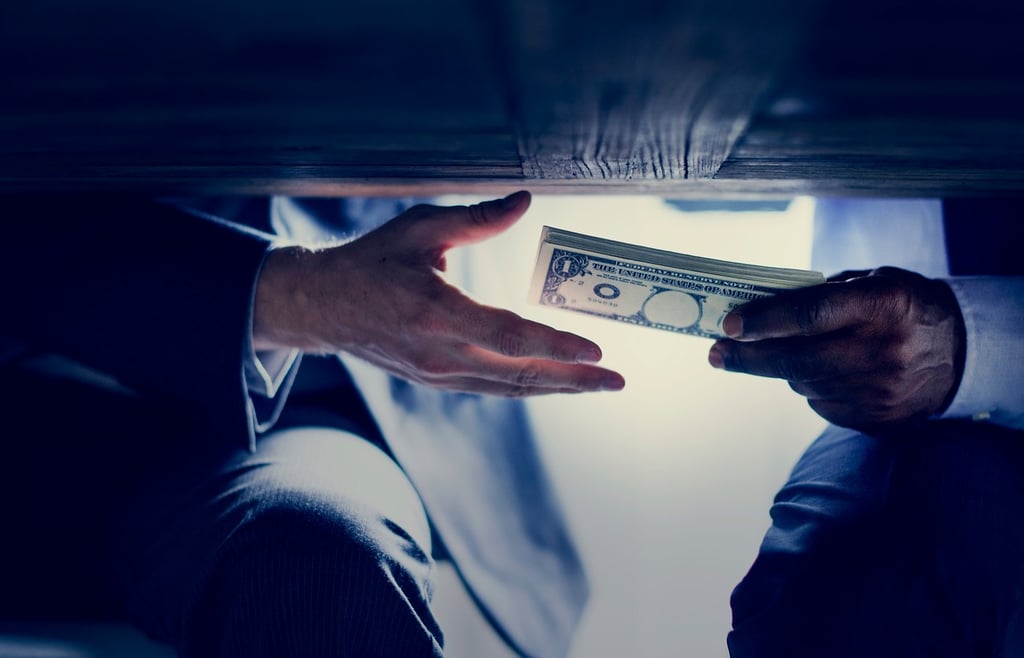 Two persons exchanging money under the table.