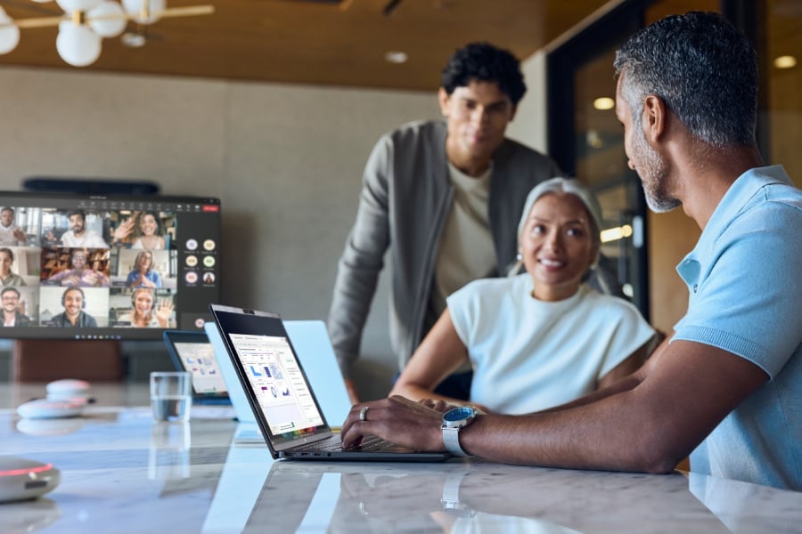 Employees using HP laptop while at virtual meeting in office.