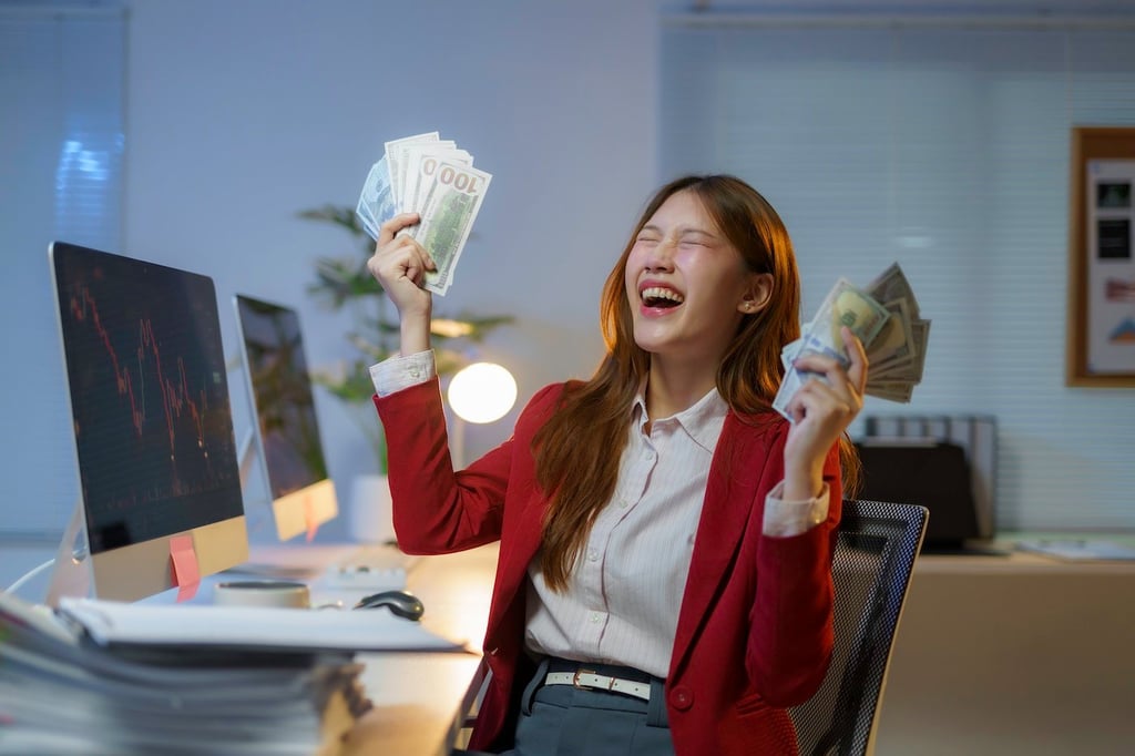 Stock photo of a businesswoman celebrating with cash in her hands.