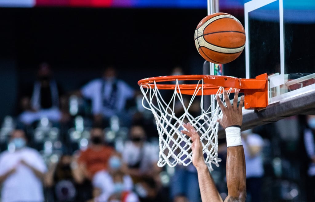 Basketball going through a hoop in a basketball game.